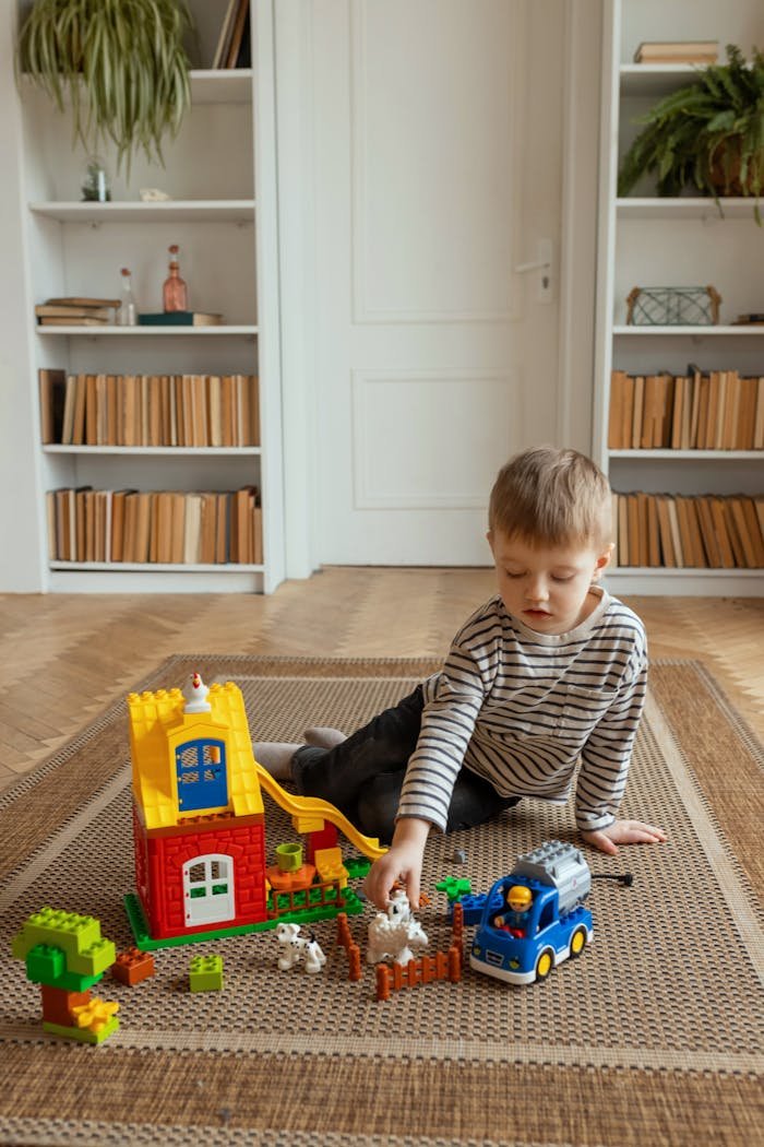 Boy Sitting On Carpet And Playing With Toys 18990725